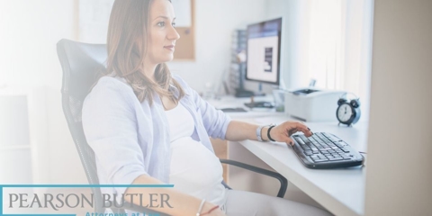 Pregnant woman typing on a computer